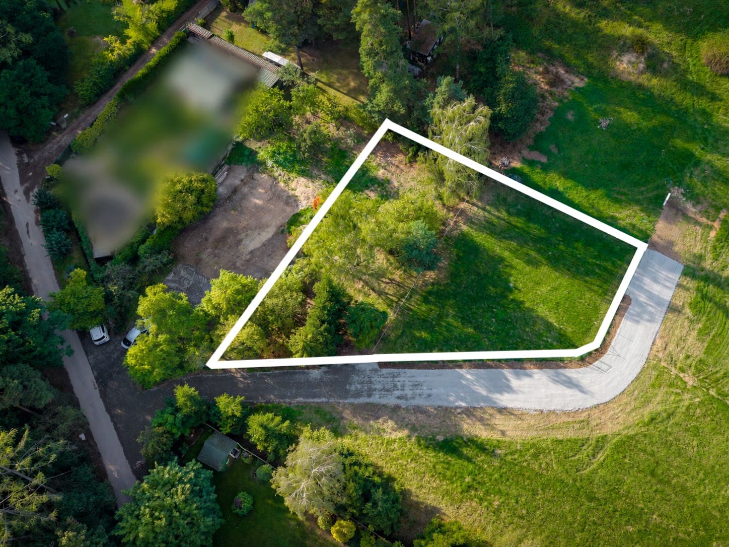 Pozemek 2 v 1 z dronu s vyznačenou hranicí a novou příjezdovou cestou